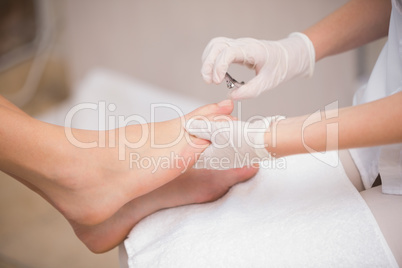 Woman getting a pedicure from beautician