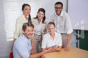 Smiling business people using digital tablet in meeting