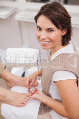 Pedicurist working on customers nails