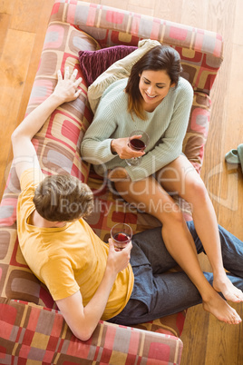 Young couple enjoying red wine on the couch