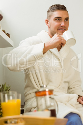 Man drinking coffee in his bathrobe