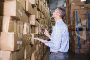 Manager holding clipboard in warehouse