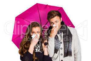 Couple blowing nose while holding umbrella