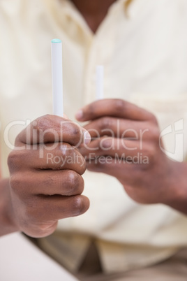 Businessman holding electronic cigarette and cigarette