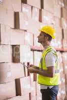 Warehouse worker using digital tablet in warehouse