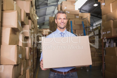 Worker carrying box in warehouse