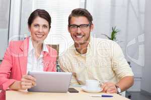 Business colleagues holding coffee cup and digital tablet