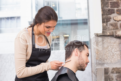 Handsome man getting his hair trimmed