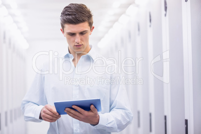 Concentrating young technician working with his tablet