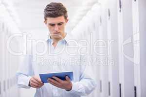 Concentrating young technician working with his tablet