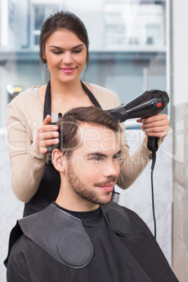 Hair stylist drying mans hair