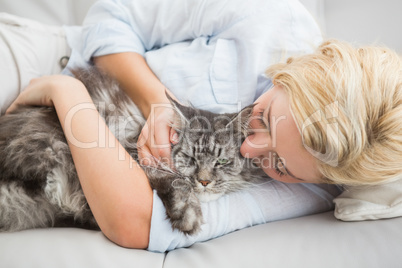 Happy blonde with pet cat on sofa