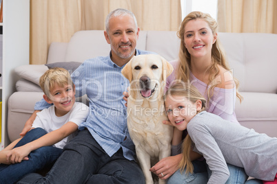 Parents and children on rug with labrador