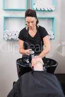 Hairdresser washing clients hair