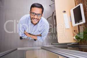 Smiling businessman with arms crossed at office