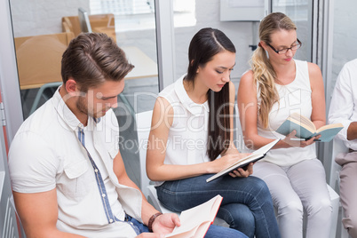 Casual business team sitting reading books