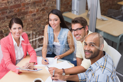 Business people taking notes and using tablet at a meeting