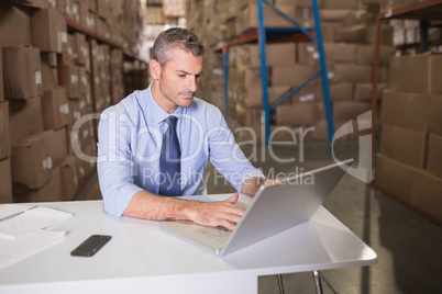 Warehouse manager using laptop