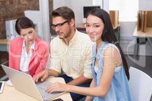 Business team working together with one smiling at camera