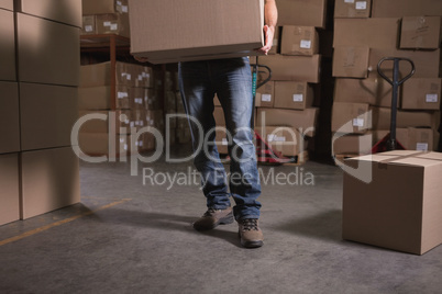 Worker with box in warehouse