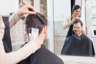 Handsome man getting his hair trimmed