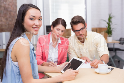 Casual businesswoman smiling at camera during meeting
