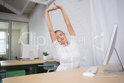 Businesswoman stretching hands in office Businesswoman stretching hands in office