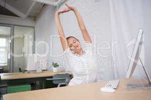 Businesswoman stretching hands in office