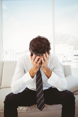 Frustrated businessman with head in hands