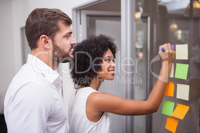 Casual business team looking at sticky notes