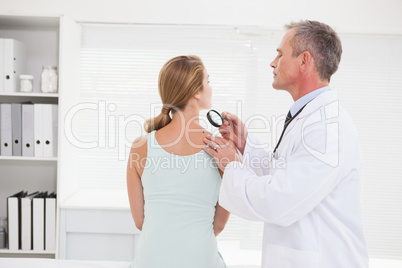 Doctor examining a brown spot