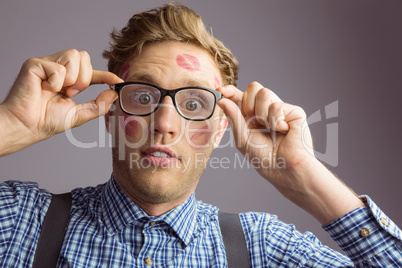 Geeky hipster covered in kisses