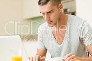 Man using his laptop at breakfast