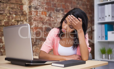 Troubled woman sitting at his desk with a laptop