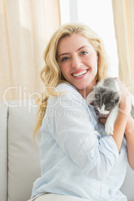 Pretty blonde with pet kitten on sofa