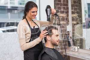 Hair stylist drying mans hair