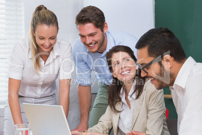 Casual business team having a meeting using laptop