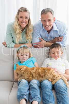 Cute family relaxing together on the couch with their cat