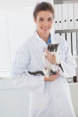 Smiling vet with a cute kitten in her arms