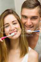 Cute couple brushing their teeth