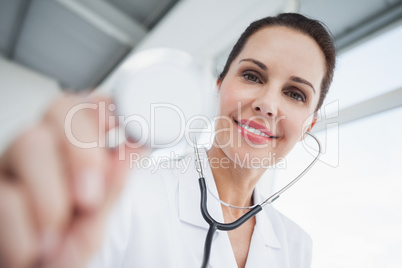 Smiling doctor checking a heartbeat