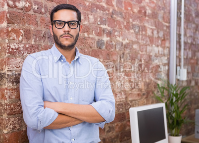 Serious businessman with arms crossed at office