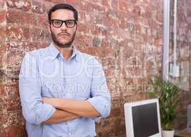 Serious businessman with arms crossed at office