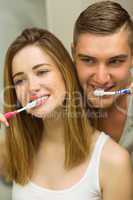 Cute couple brushing their teeth