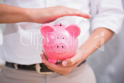 Mid section of man holding piggy bank