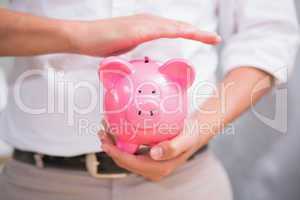 Mid section of man holding piggy bank