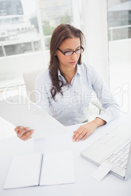 Happy businesswoman using laptop at her desk