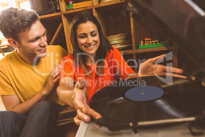 Young couple putting on a vinyl record