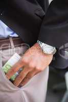 Businessman keeping currency in pocket