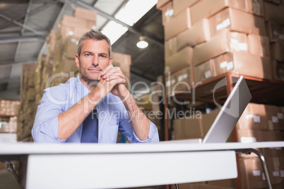 Portrait of warehouse manager with laptop